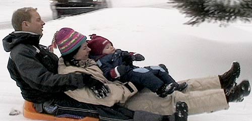 family on snow sled